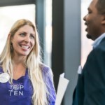 Shows two happy business people engaging in conversation at a corporate event