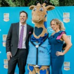 Couple posing with George mascot at Valley Children's